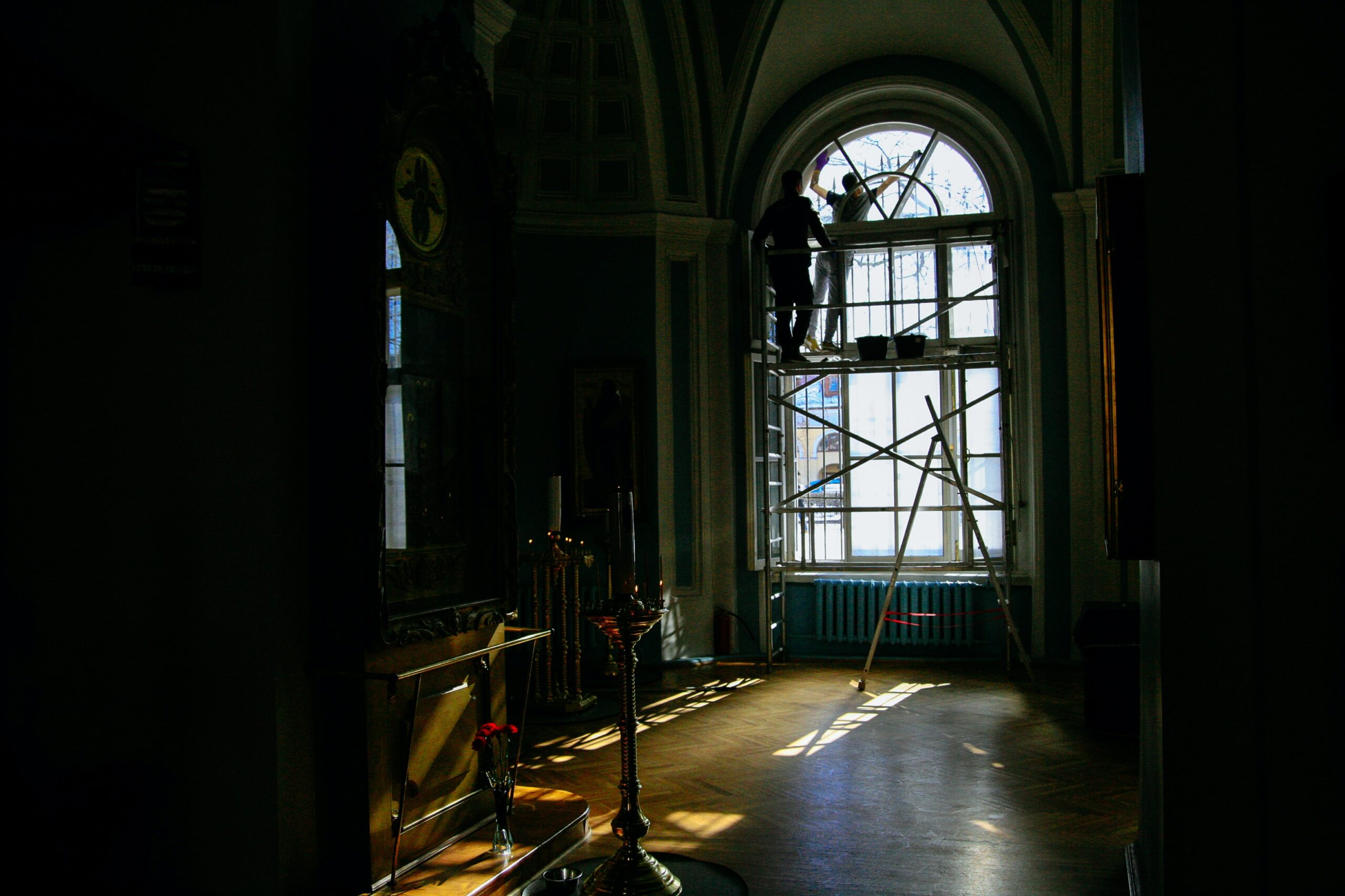 restoration and cleaning of a large arched window, backlit