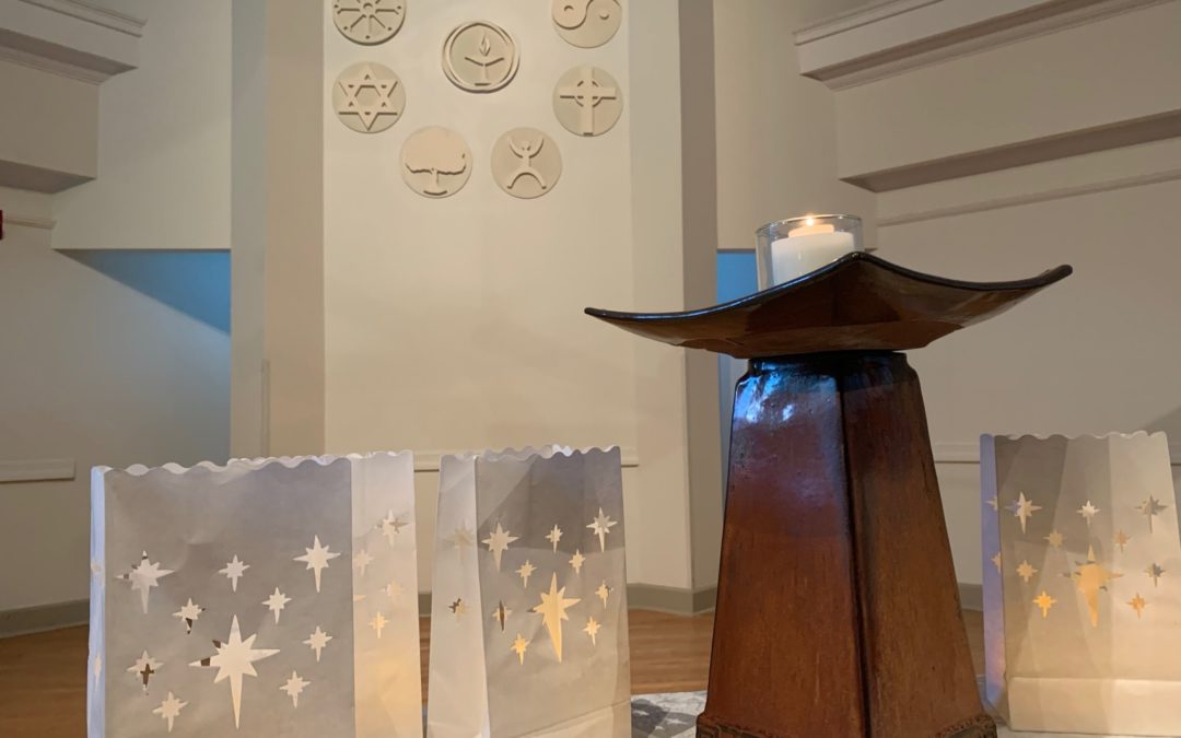 image of modern chalice with candle in church sanctuary with many religious symbols visible behind it